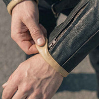 Hand opening of a black leather motorcycle jacket