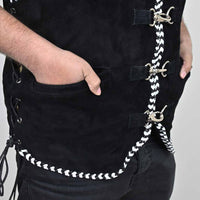 Black apron with white braided strap worn by a person on a plain background